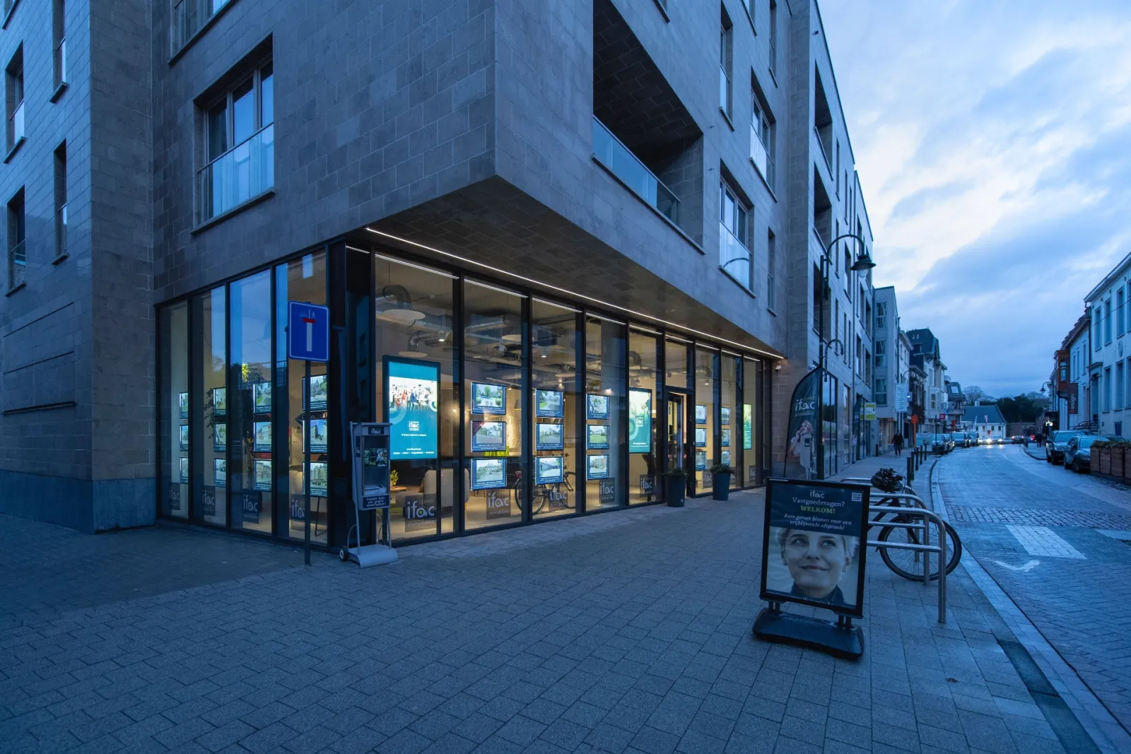 Het kantoor van Ifac Service op de hoek van de straat, met de verlichte etalage