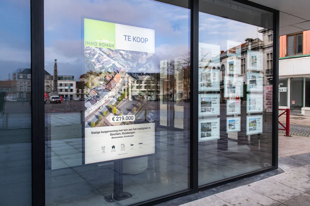 Staand scherm met een woning te koop in de etalage van Immo Roman