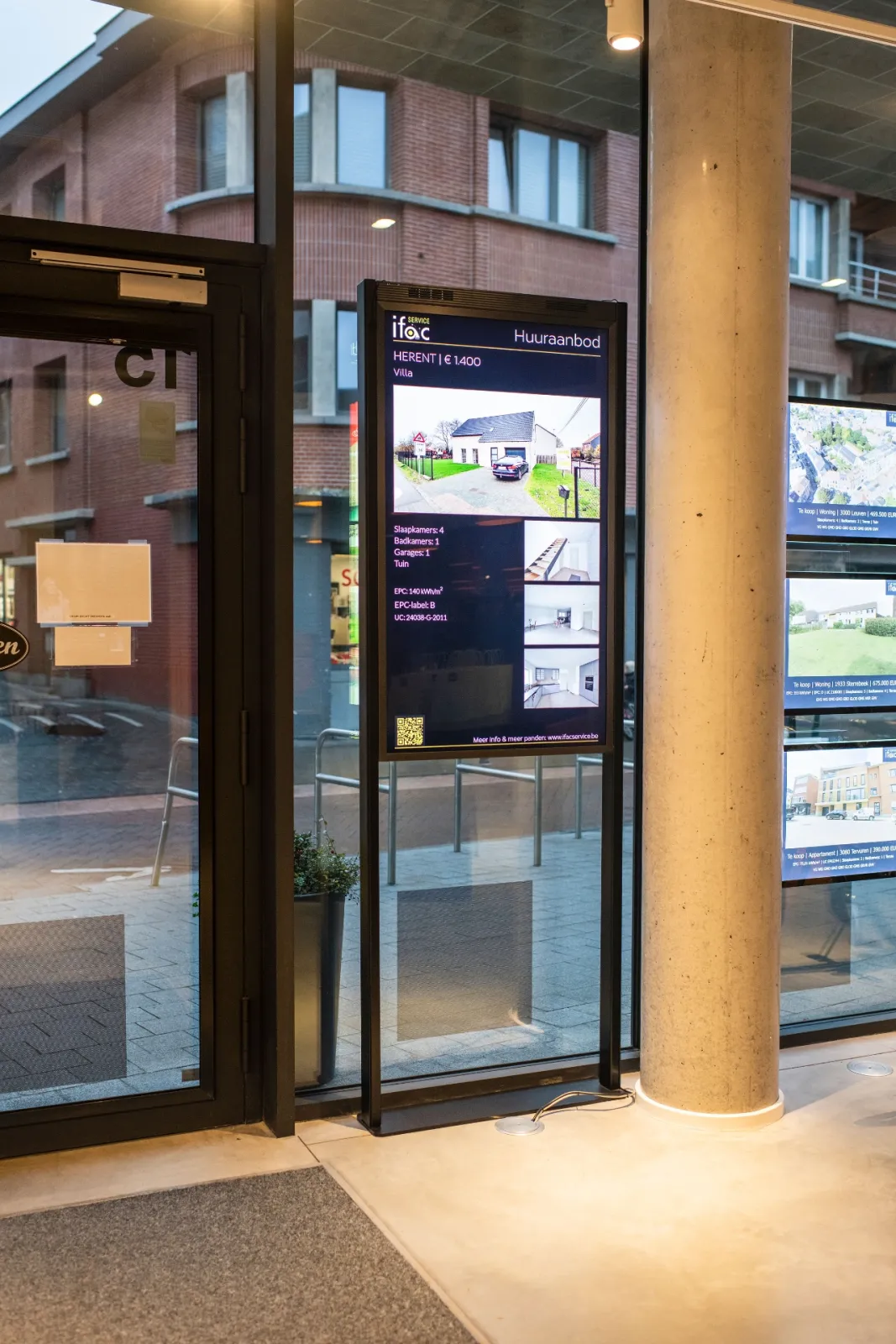 Een staand scherm bij de glazen deur van Ifac Service, met een woning te huur