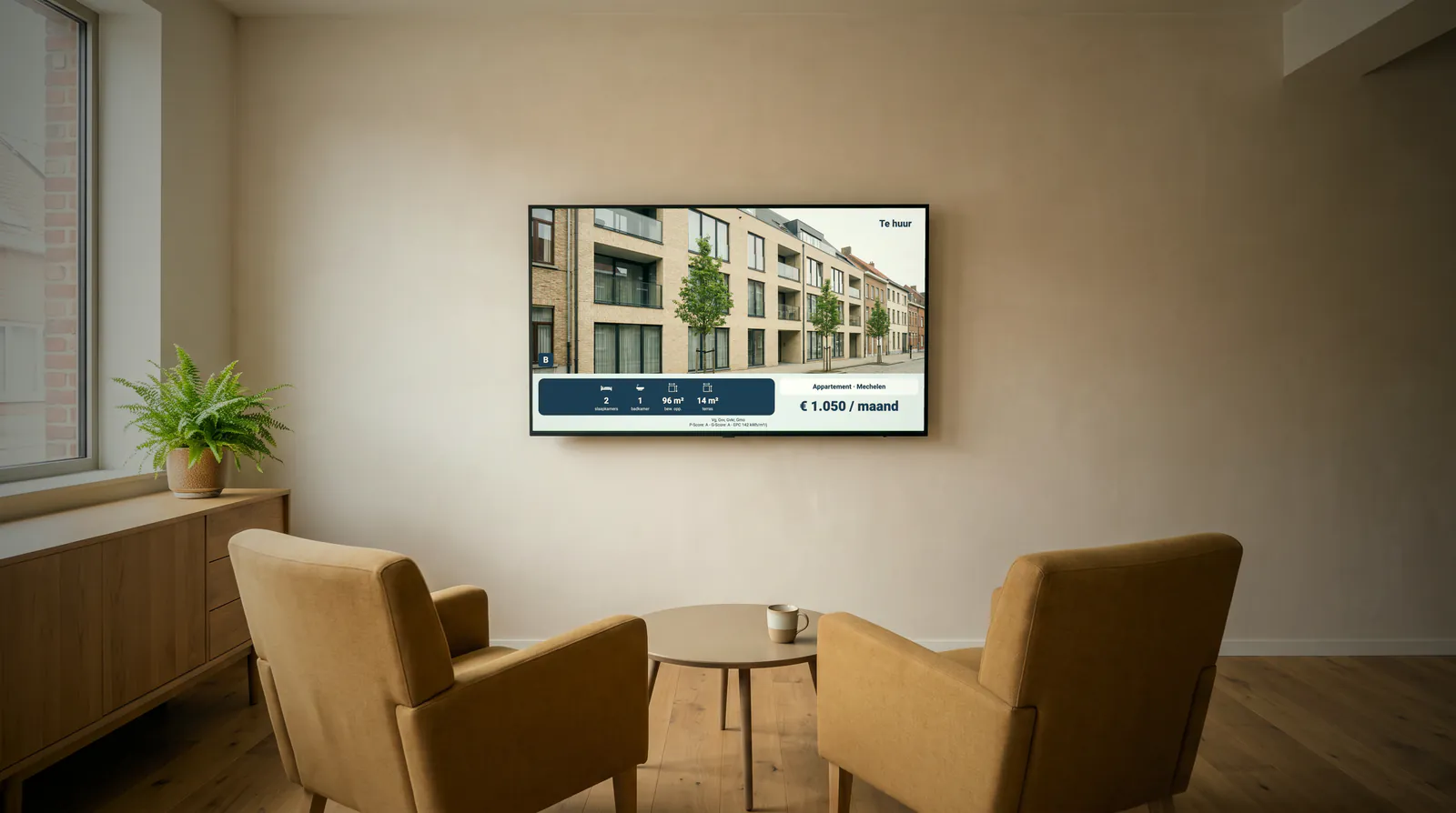 Wachtruimte van een immokantoor met twee fauteuils rond een salontafel, en aan de muur een scherm met een appartement te huur in Mechelen